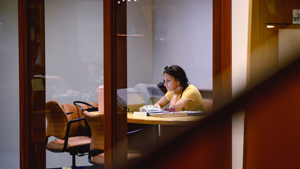 a female student looking at her laptop in a study room